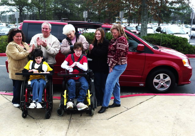 Jessica Wilson and Donnie Gooding are surrounded by family in front of the handicap van that will take them to the prom together.