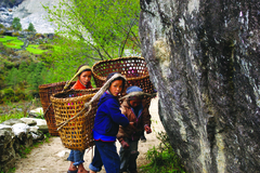 Sherpa children carrying baskets strapped to their heads