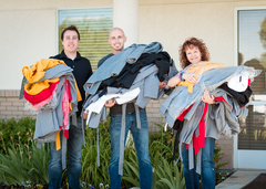 Mike McEwan, Very Jane CEO (left), JD Stice, Very Jane COO (center), and Bobbi McGraw, Safe Harbor volunteer (right), carry donated coats to the women's shelter.