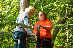 Barbara Stetson (left) is greeted at one of the treetop platforms during her climb at The Adventure Park at The Discovery Museum by park employee Ceili Grinnell. (Photo: Outdoor Ventures)