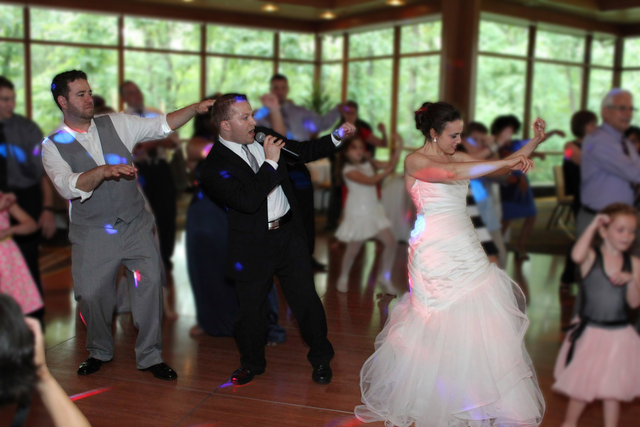 Paul on the dance floor with a bride and groom
