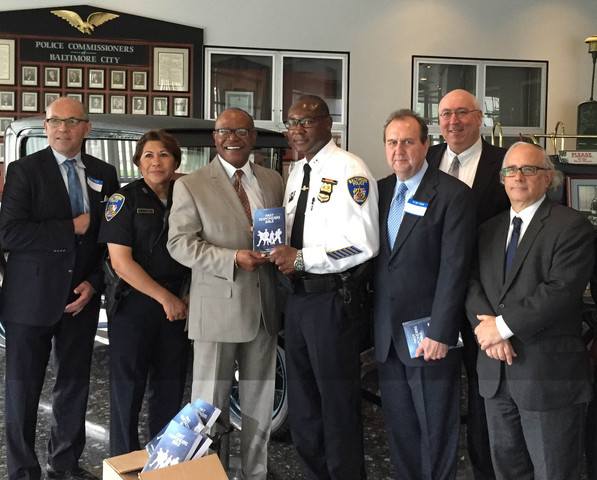 Reverend Al Hathaway (left) presents a First Responder Bible to the Baltimore Police Department along with Joey Hudson (right).