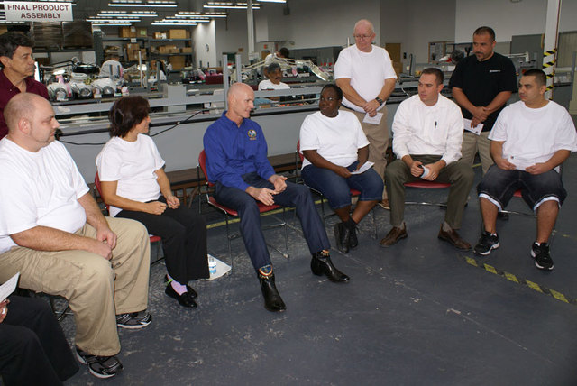Gov. Rick Scott sits with a handful of employees at Advanced Protection Technologies to ask them ideas about how to create new jobs.