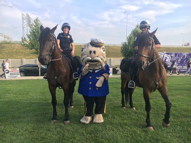 Catfish Louie, the official mascot for the Friends of the Waterfront, poses with Louisville police officers during the 2017 Fourth of July celebration in Louisville, KY.
