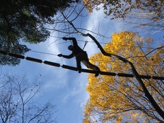 A climber at The Adventure Park seen agains the backdrop of an autumn sky and trees. (Outdoor Ventures Photo)