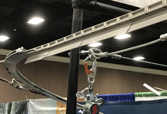 Portion of Quantum Zip Line System track, at Ropes Park Equipment' booth at ACCT, showing section that activates speed reduction where trolley approaches a curve.