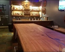 This live edge wooden table was custom built from White Oak by River City Wood Design for Troll Pub, a local bar in Louisville, Kentucky. 