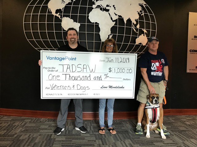 Lane Mendelsohn, president of Vantagepoint AI, presents a donation to Lynn Colombo, Cory Ball, and Nick of TADSAW